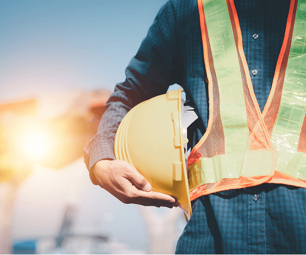 Construction worker in safety gear at sunset